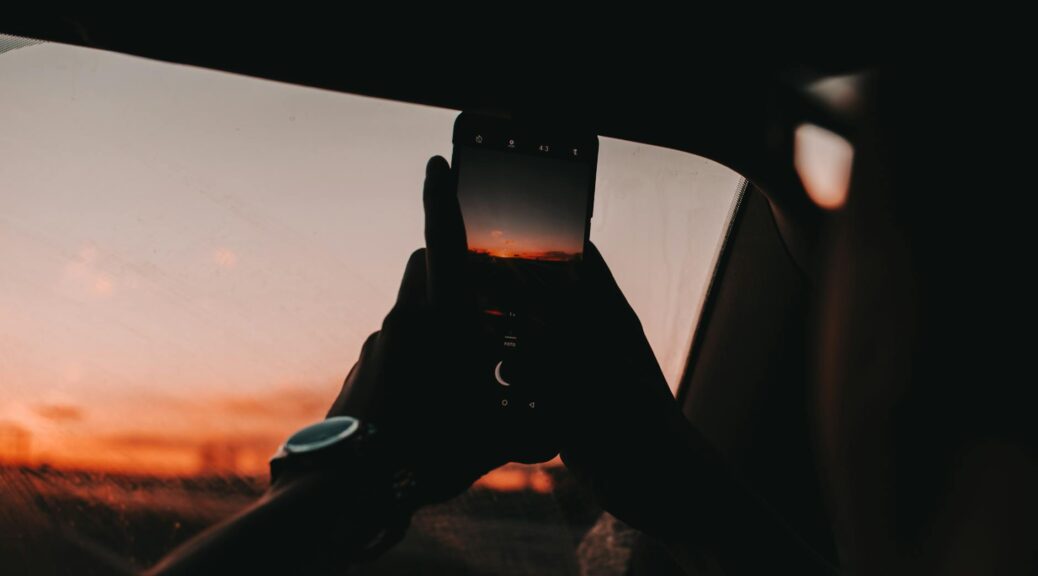 person using smartphone during golden hour